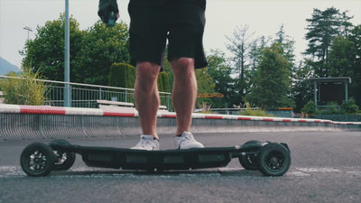 Rider bouncing on the ONSRA BLACK CARVE 4 electric longboard
